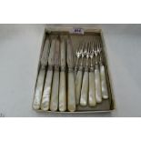 A part set of silver dessert knives and forks having engraved blades and mother of pearl handles,