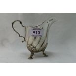 A Victorian silver cream jug having trefoil scallop and hoof feet, loop handle and line