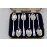 A cased set of six silver teaspoons having golf interest to terminals, Sheffield 1933, Walker &