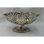 A silver table basket of oval form having pierced decoration and moulded rim on a pedestal foot,