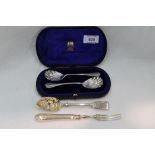A cased pair of Victorian silver jam spoons having scalloped bowls and embossed terminals, London