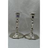 A pair of Edwardian silver candle sticks of octagonal form having removable sconces, shaped