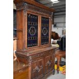 A Victorian oak bookcase having cupboard base, with lion mask carvings, upper section with