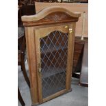 A modern oak corner cupboard with leaded effect glass