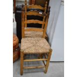 A pair of ladder back rush seated kitchen chairs