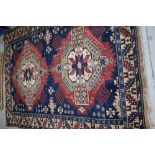 A Persian rug, in crimson, blue and cream, approx. 192 x 136cm