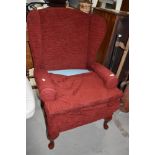 A modern wing back armchair in wine red upholstery