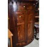 A 19th Century mahogany bow fronted corner cupboard having drawer base (single drawer flanked by two