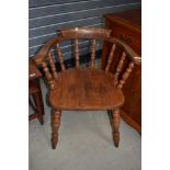 A traditional stained frame smokers bow style armchair