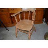 A traditional stripped spindle back elbow chair