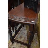 A mid 20th Century oak twist gate leg dining table with carved decoration