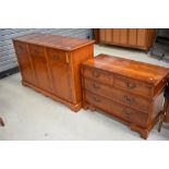 A reproduction yew wood sideboard and entertainment unit modelled as a chest of drawers