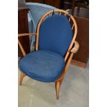 A vintage Ercol low carver chair having typical hoop and stick back design