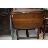 A dark stained Ercol style drawer leaf dining table, approx. width 47cm