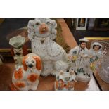 A selection of Staffordshire flat back figures including dogs money box and figure pair