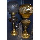 Two late 19th early 20th oil lamps having decorative glass shades and brass bases.