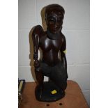 A large hand carved figure of an exotic hunter possibly Indonesian standing