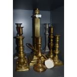 A selection of heavy set candle sticks and brass roman column lamp.