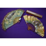 Two oriental hand painted paper fans, one having fringing to edge and both with wooden ribs.