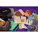 A metal sailors hat tin containing an assortment of 50s dress patterns, stockings,scarves and