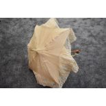 An early 20th century cream slub silk parasol with an abundance of tulle lace surrounding the