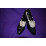 A pair of antique black leather and cream suede shoes with stack heel and mother of pearl button