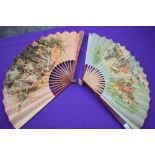 Two large paper fans, one having classical scene and gilt detailing to wooden ribs, the second