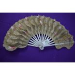 A Victorian fan having hand painted floral paper and gauze like leaves with gilt detailing and