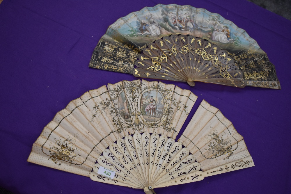 Two lithographic fans, first one having pierced bone ribs and scene of women and rural scenery,