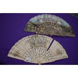 Two lithographic fans, first one having pierced bone ribs and scene of women and rural scenery,