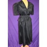 A vintage 1940s black dress with peplum waist, covered buttons to front and belt to waist,larger