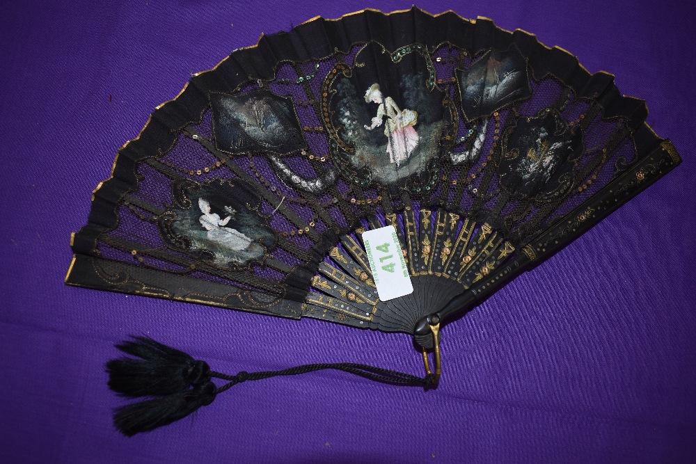 A Victorian black gauze and net fan having painted inserts depicting ladies and countryside scenes.