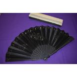 A large boxed early 20th century black silk fan with sequins and spangles forming butterflies to the