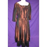 A vintage 1940s full length red evening dress trimmed with black towards the hem, with extensive