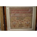 A framed sampler by emma Coupe, aged 10 1862, depicting a deer,alphabet, religious text,and floral