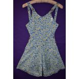 A 1940s cotton playsuit having bright floral print, buttons to both sides and buttons to front of