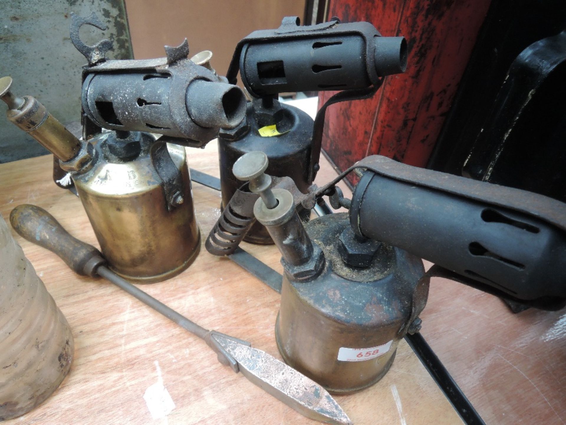 Three brass blow torches and soldering iron.
