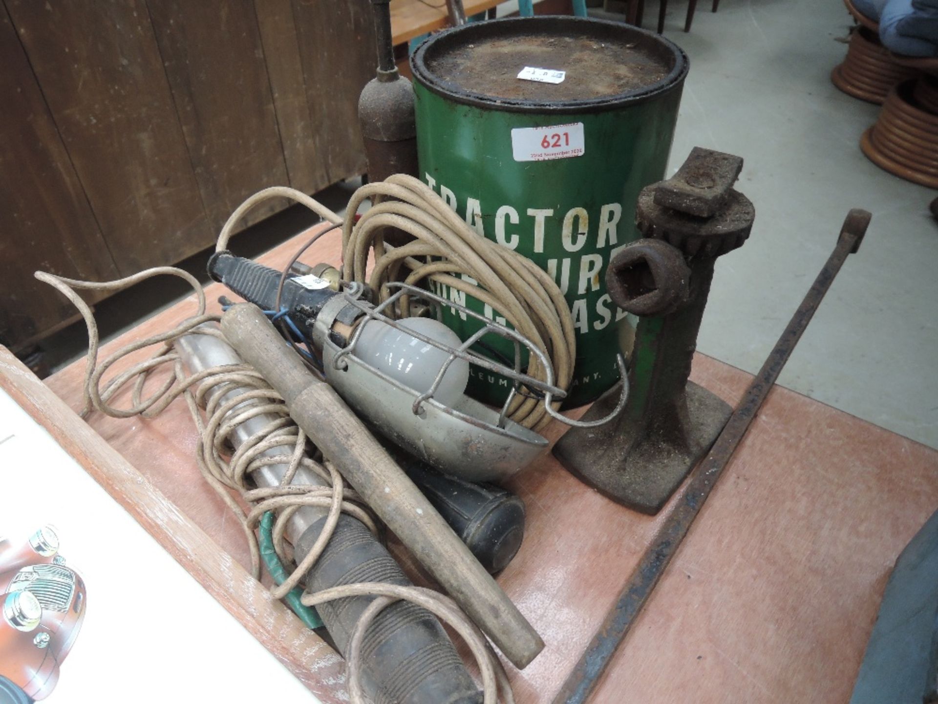 A selection of Grease guns, tin of tractor grease, inspection lamps and early car jack.