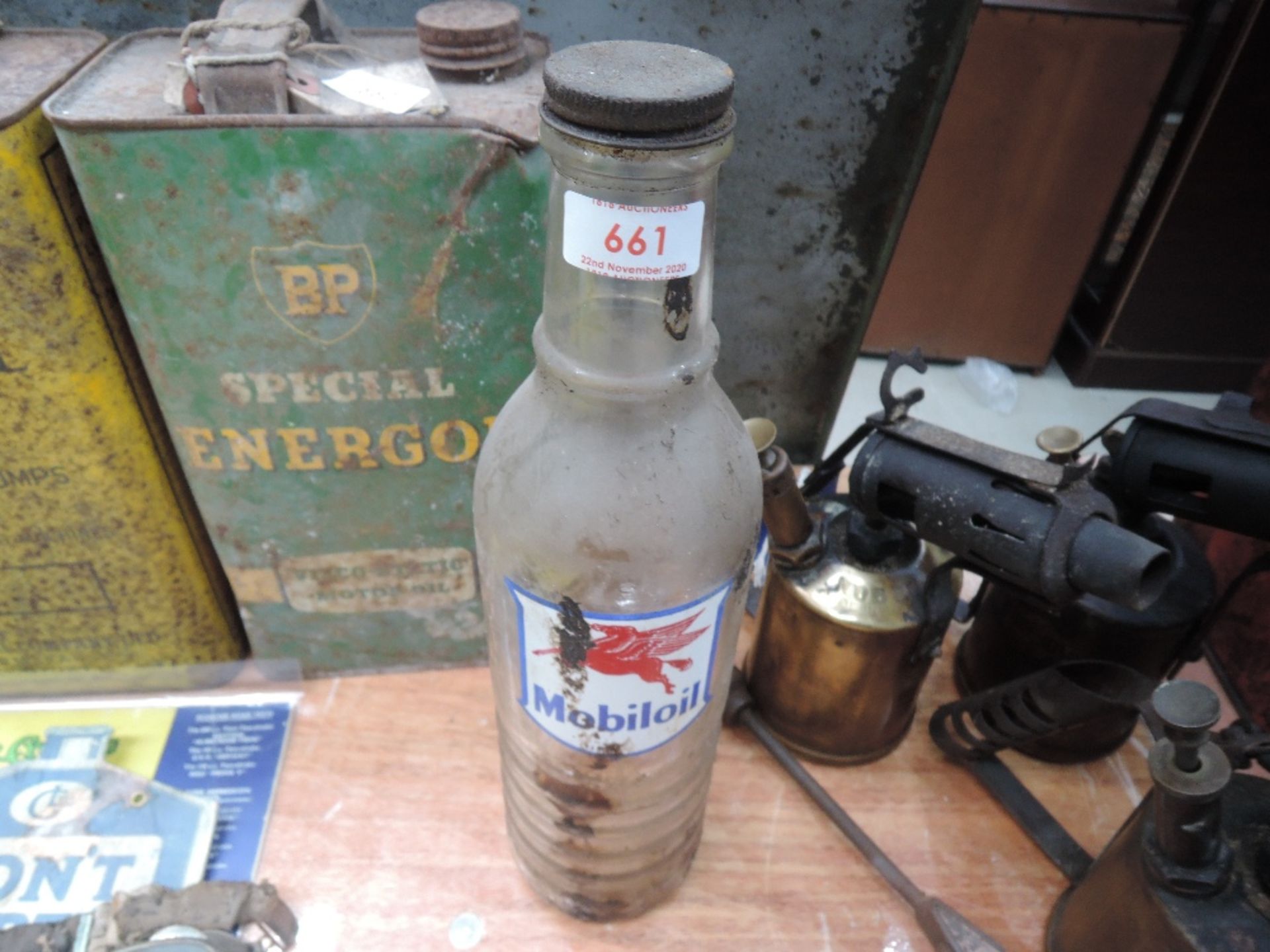 A glass Mobiloil oil bottle with original cap.