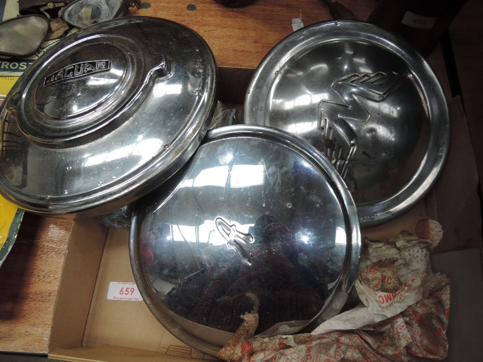 Three car hub caps, for Jaguar, Austin and Wolsey and an assortment or vintage key rings.