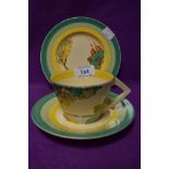 A Clarice Cliff trio having sea and landscapes to cup and plate and green and yellow banding to