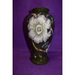 A Moorcroft baluster shaped vase having floral design on dark green ground.