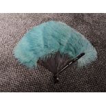 A vintage ostrich feather fan having teal blue colour and early plastic ribs.