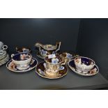 A selection of antique tea cups and milk jug including hard paste with individual hand decorated
