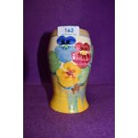 A Clarice Cliff bizarre vase having pansy design on cream and yellow ground.