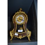 A French style balloon clock having extensive brass detailing and visible pendulum with enamel