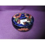 A Moorcroft lidded bowl having Anemone pattern on blue ground.