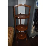 A folding cake or tea stand in mahogany with banding and inlay detail