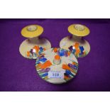 Thee item of Bizarre, Crocus by Clarice Cliff Newport potteries,A pair of candlestick holders and