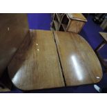 A light stained mahogany winding dining table with leaf